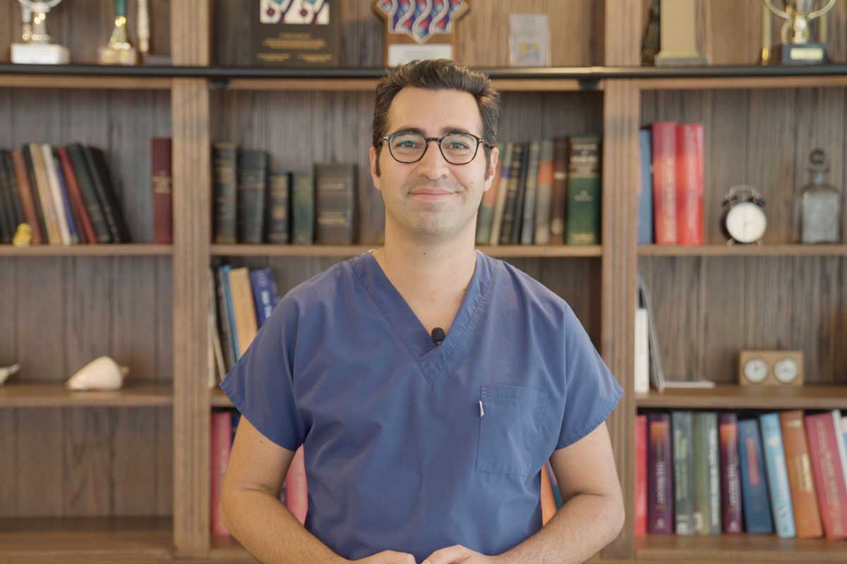 Dr. Ali Emre Karadeniz speaking in front of his library